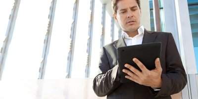 Businessman looking at a tablet in his hands.
