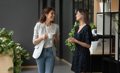 Two women drinking coffee in the office,