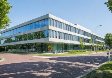 Dutch Institute for Fundamental Energy Research, a modern glass-walled building in daylight.