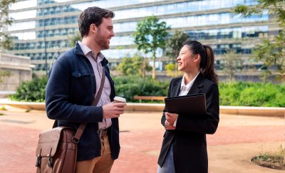 Coworkers chatting in front of an office building.