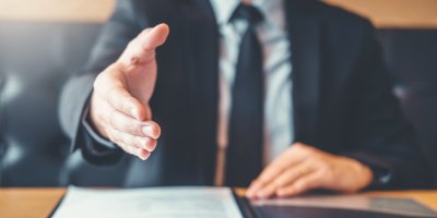 Man giving hand shake after signing contract.
