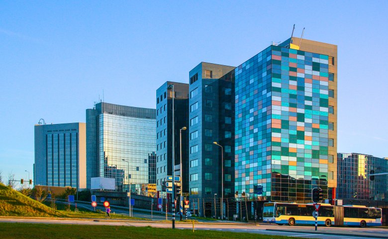 Glass midrise office building with colorful windows reflecting the sky