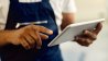 Close up mechanic working on tablet