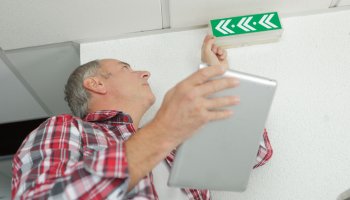 Man checking emergency signs in building