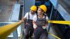 Two maintenance workers climbing stairs in a factory.