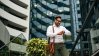 Business man looking at his watch in front of real estate buildings