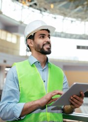 Engineer working on tablet by building inspection