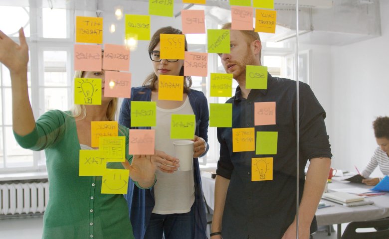 Colleagues brainstorming with sticky notes in a flexible workspace