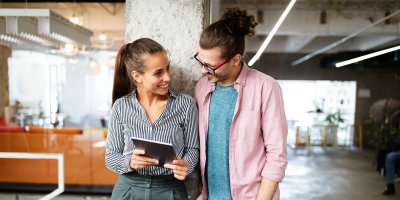 Two people smiling looking at tablet