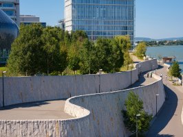 Heightened walkway with trees alongside it towards a building