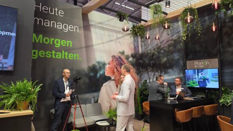 Video interview recording taking place in front of the Planon Real Estate exhibition stand.