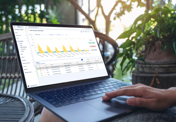 Employee working on laptop with dashboard.