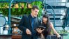 Two people looking at a tablet in a greenhouse.