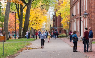 People walking on the campus road with University real estate building.