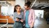 Two people smiling looking at tablet