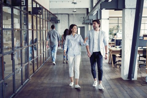 Man and woman walking in a office building.