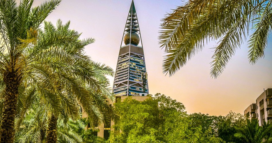 Image showing the Al-Faisaliah-Tower in Riyadh with lots of green plants and palmtrees.