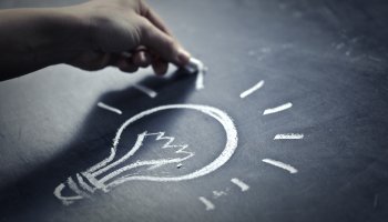 Man drawing a light with chalk on a board