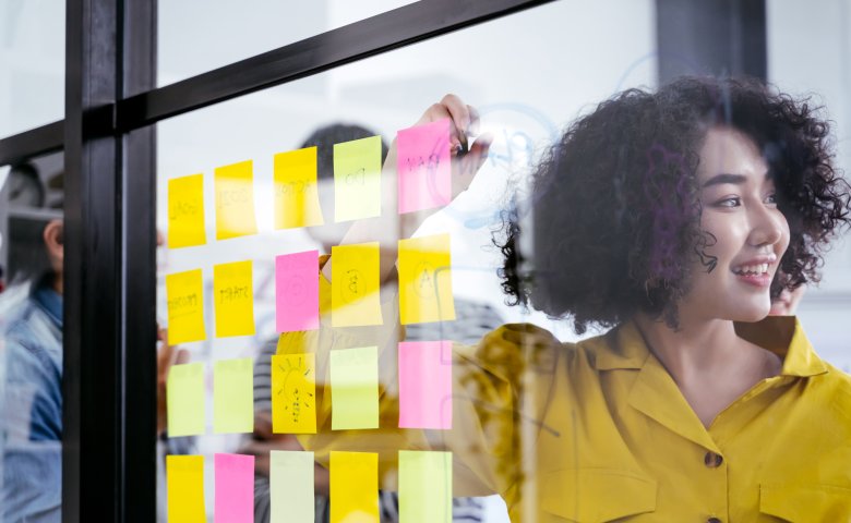 Employee brainstorming with post-its in the office building