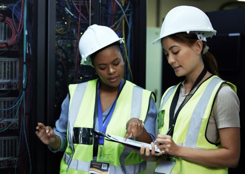 Two female maintenance engineers checking their work orders.