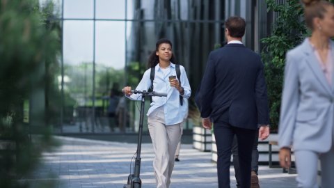 Business people walking and smiling in front of building.