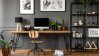 Home office with a computer and lush green plants.