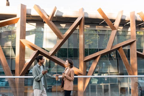 Two friends socializing in front of real estate building