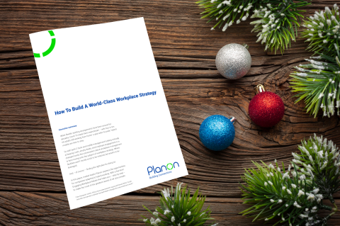 Cover of "How to build a world-class workplace strategy" Planon whitepaper surrounded by Christmas decorations.