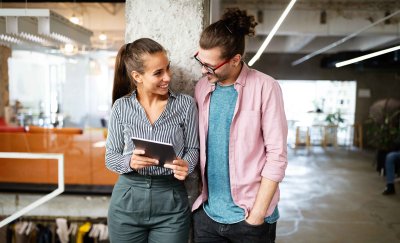 Two people smiling looking at tablet