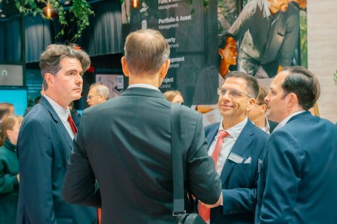 Close-up of people engaged in a conversation at a trade fair.