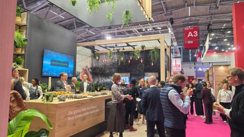 Overview of the media breakfast at the Planon Real Estate stand with guests enjoying refreshments and networking.