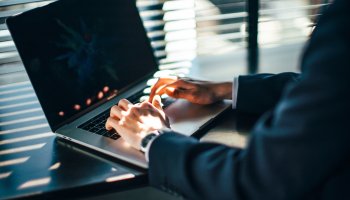 Man typing on laptop.