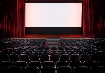 Empty filmtheatre with red curtains and white screen