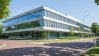 Dutch Institute for Fundamental Energy Research, a modern glass-walled building in daylight.