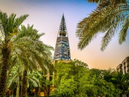 Image showing the Al-Faisaliah-Tower in Riyadh with lots of green plants and palmtrees.