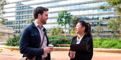 Coworkers chatting in front of an office building.