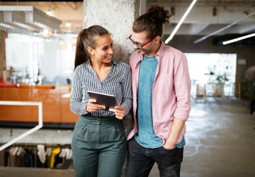 Two people smiling looking at tablet