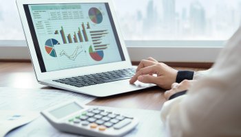 Man processing financial data on laptop