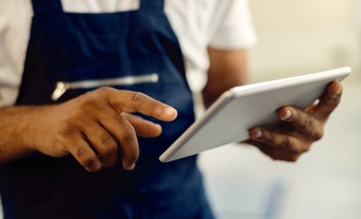 Close up mechanic working on tablet