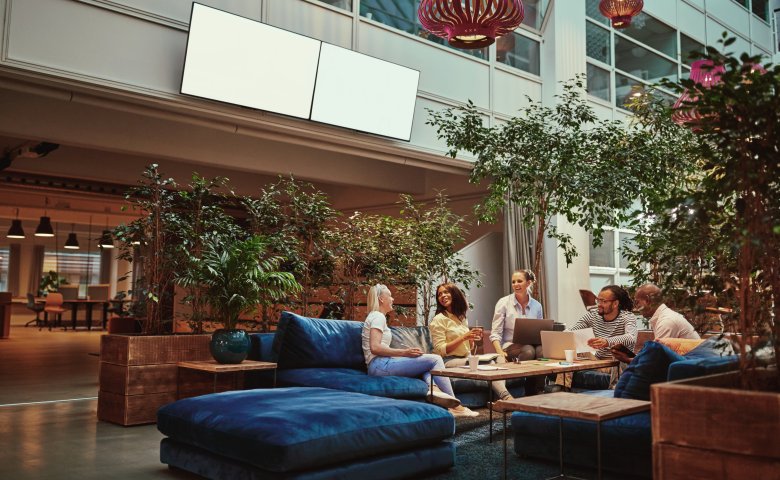Three women sitting and talking in a clean meeting area.
